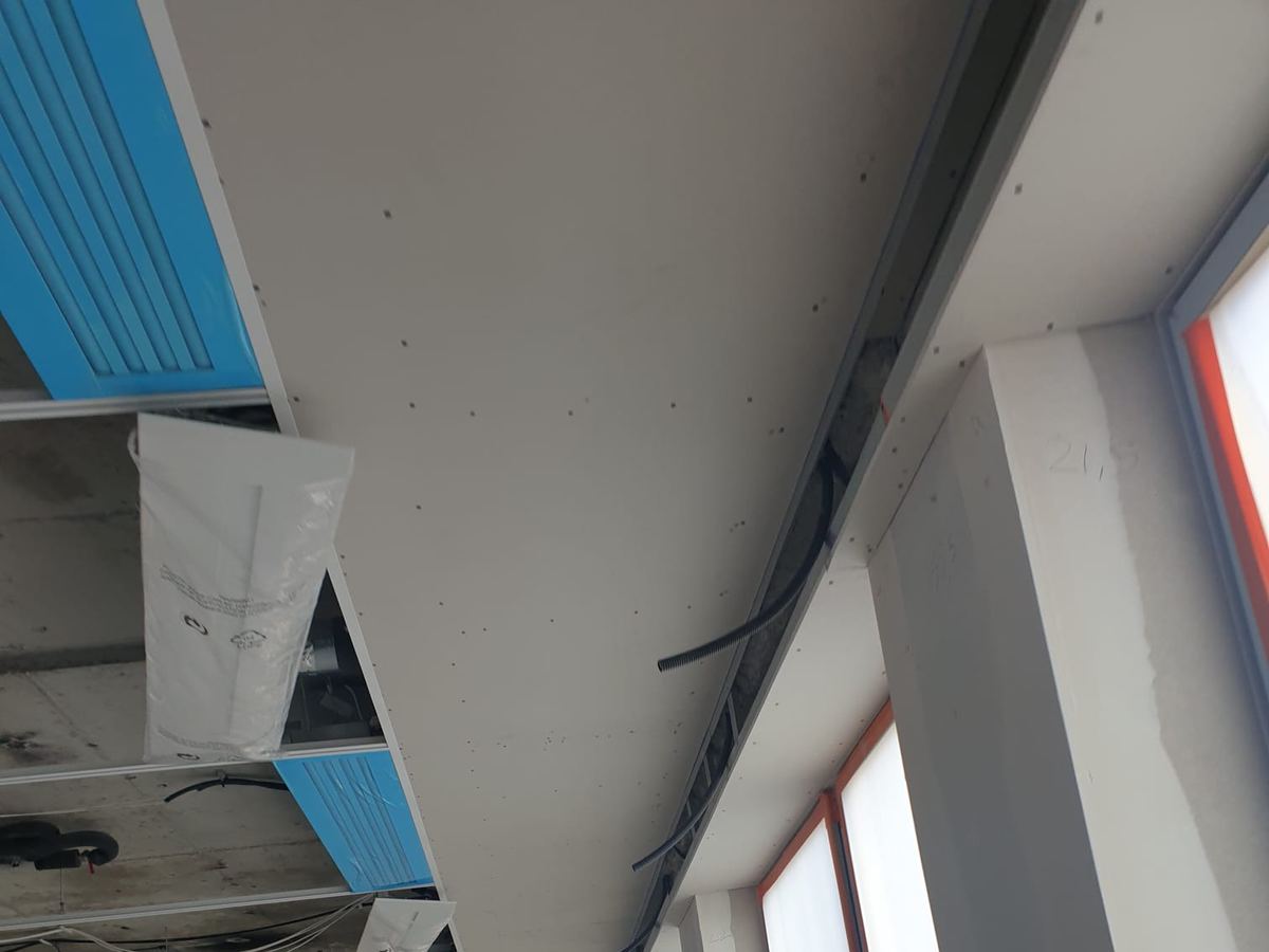 Faux-plafond technique en cours de fermeture dans un espace tertiaire, réseaux et luminaires intégrés en plénum