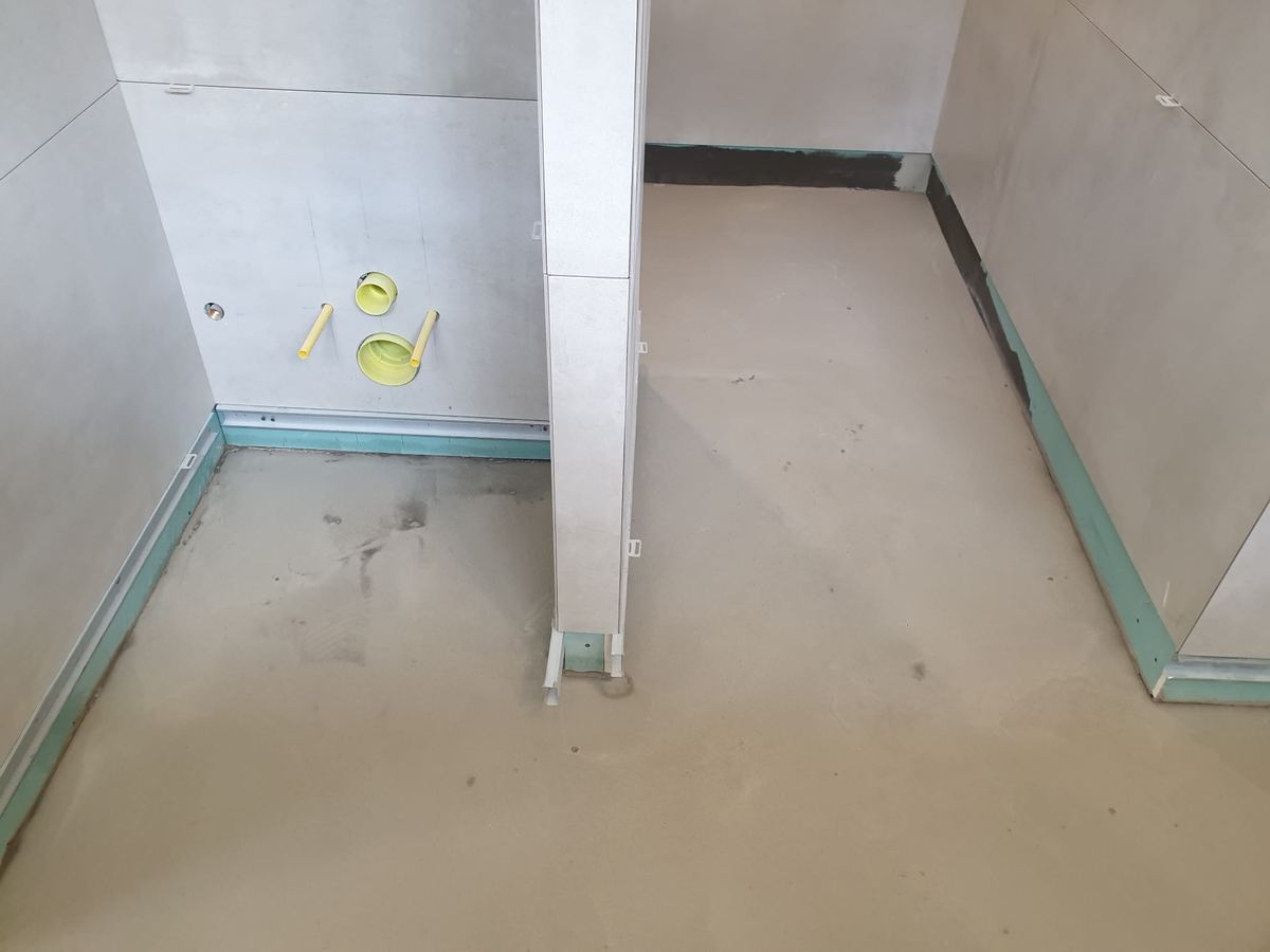 Bande d'étanchéité périphérique posée en pied de cloison avant carrelage d'un espace douche